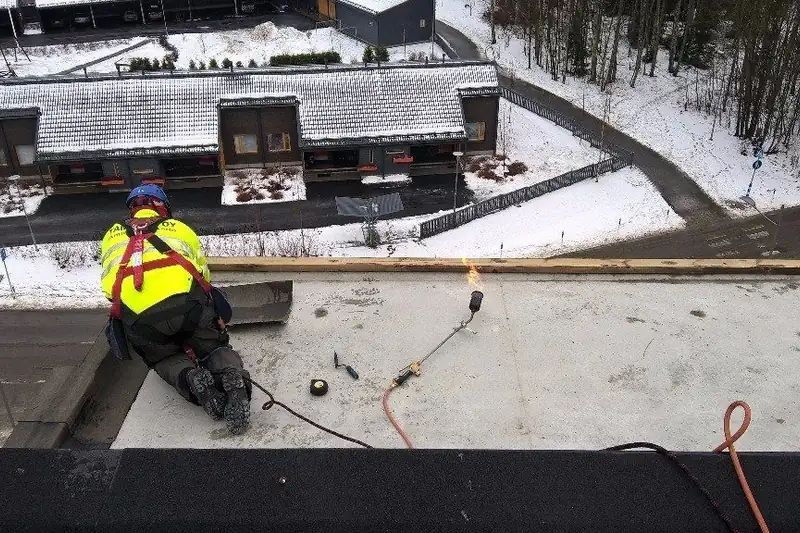 Asentaja työskentelee lumisella katolla