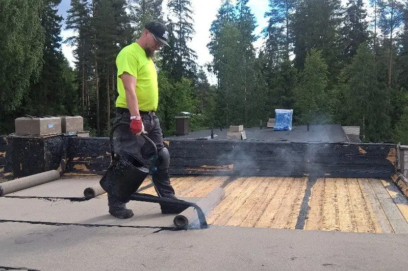 Asentaja hitsaa kermiä katolla polttimella